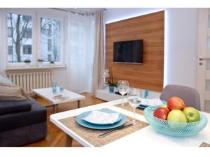 een woonkamer met een tafel met een fruitschaal bij Srebrna Warsaw Apartment in Warschau