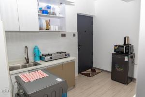 a small kitchen with a sink and a refrigerator at The Nirvana Place in Nairobi