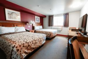 a hotel room with two beds and a desk at Bay City Inn in Bellingham