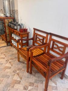 two wooden benches in a room with a stove at Hotel Mão de Fatima in Aparecida