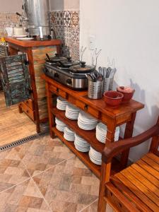 a table with a stove and a stack of plates at Hotel Mão de Fatima in Aparecida