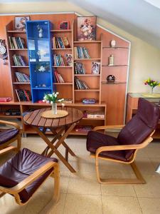 a room with a table and chairs and book shelves at Мирели in Ravda