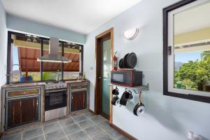 a kitchen with a stove and a microwave at The Ceiba Villa by Otium in Aguas Claras