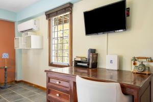 a room with a desk with a tv on the wall at The Ceiba Villa by Otium in Aguas Claras