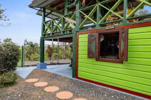 a green building with a window on the side of it at The Ceiba Villa by Otium in Aguas Claras +35 photos