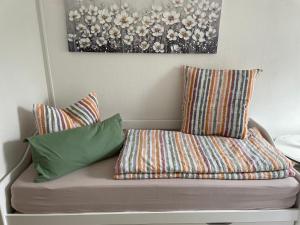 a couch with two pillows and a painting on the wall at Mein kleines Reich in Zwickau +13 photos