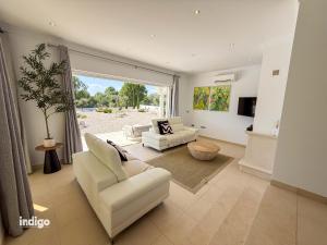 a living room with white furniture and a large window at Villa Nichan - Private Pool - NIC01 in Ayamonte