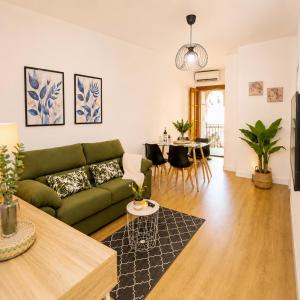 a living room with a green couch and a table at Apartamento en Cazorla con balcón privado y vistas a la montaña in Cazorla