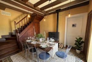 a dining room with a table and chairs and a staircase at Le CLOS D'ETRETAT in Les Loges