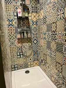 a bathroom with a tile wall with a toilet at Maisonnette Cosy Villa Ajna in Bayonne