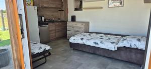 a small bedroom with a bed and a kitchen at Chata Heřmaň in Heřmaň