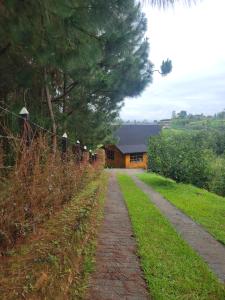 a brick road leading to a house with a fence at Cozy Cabin in avocado farm in Marinilla