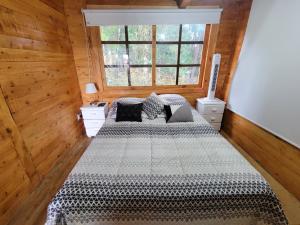 a bedroom with two beds and a window at Cozy Cabin in avocado farm in Marinilla