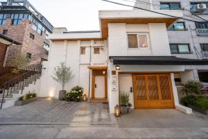 a white house with wooden doors in a city at On Stay - Hotel Quality Stay in Seoul