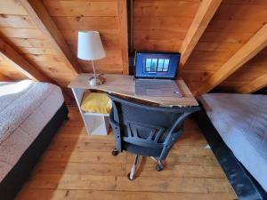 a laptop computer on a desk in a tiny house at Cozy Cabin in avocado farm in Marinilla