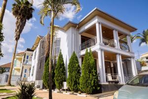a house with palm trees in front of it at Poolside View Guest House in Kigali