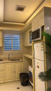 a kitchen with a refrigerator and a microwave at شقق فندقية 2 in Buraydah