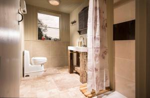 a bathroom with a toilet and a sink and a window at Sunbank Yurt in Llangollen