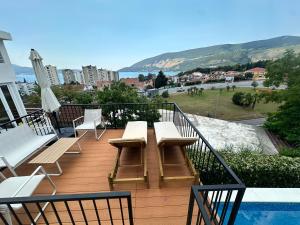 a balcony with benches and a table and a pool at Al Mare Vacation Home in Igalo