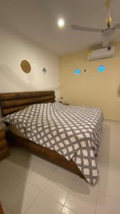 ein Schlafzimmer mit einem Bett mit gestreifter Bettdecke in der Unterkunft Corazón Abierto in Chicxulub