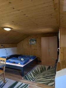 a bed in a room with a wooden ceiling at Apartmán Gál 2 in Kvačany
