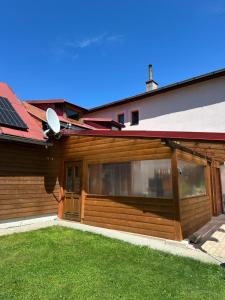a house with a wooden garage with a solarium at Apartmán Gál 2 in Kvačany