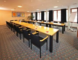 uma grande sala de conferências com uma mesa longa e cadeiras em Hotel Adler em Aalen