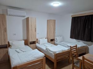 a room with two beds and a table and chairs at Apartmani Jet Set in Bor