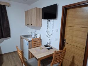 a small kitchen with a table and a television on the wall at Apartmani Jet Set in Bor +6 photos