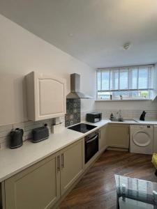 a kitchen with white cabinets and a stove top oven at The Recharge Loft in Durham