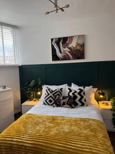 a bedroom with a large bed with a yellow blanket at The Recharge Loft in Durham