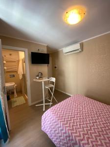 a room with a bed and a table and a television at AFFITTACAMERE PIAZZA UNITA' in Monfalcone
