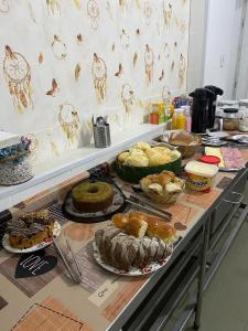 a table with many different types of cakes and pastries at Hotel Beira Rio Guararema in Guararema