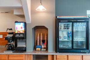 a drink station with a refrigerator and a tv at Bay City Inn in Bellingham
