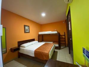 a bedroom with two beds and a green wall at Hostal Casa Huasteca in Ciudad Valles