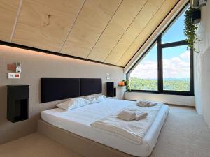 a large bed in a room with a large window at The East House ONE in Łapanów