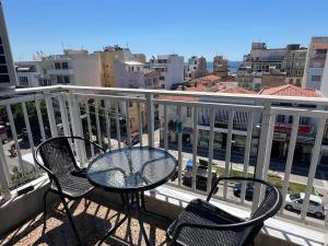 a table and chairs on a balcony with a view of a city at Downtown Hub 2 in Alexandroupoli