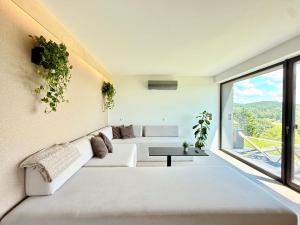 a living room with white furniture and a large window at The East House ONE in Łapanów +16 photos