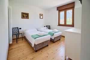 a bedroom with two beds and a window at Meridiana Gemona in Taboga
