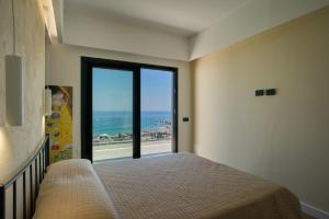 a bedroom with a bed and a view of the ocean at Villa AmOr in Cefalù