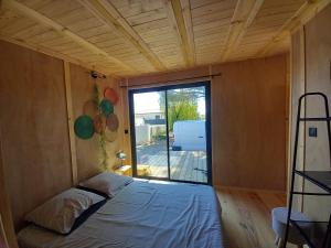 ein Bett in einem Zimmer mit einem großen Fenster in der Unterkunft la douceur du sud jardin terrasse in Clermont-lʼHérault