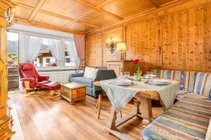 a living room with a table and a couch at Landhaus Pichler mit Sauna in Ruhpolding
