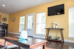 a living room with a table and a tv on the wall at Ground Floor, 3BR, Free Parking, Near Refinery -E- in Moss Point