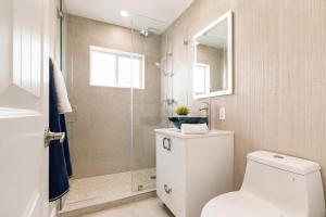 a bathroom with a toilet and a glass shower at Cozy Private Triple Room in Design District Miami in Miami