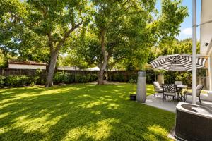 a yard with a table and chairs and an umbrella at Cozy Private Triple Room in Design District Miami in Miami