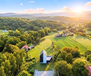 an aerial view of a house on a green field at The East House ONE in Łapanów