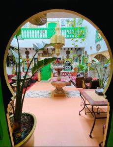 a large room with a fountain and plants in it at riad cherif in Marrakesh