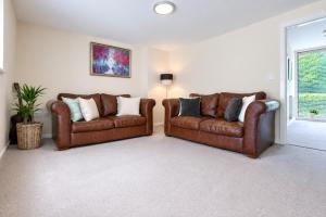 two brown leather couches in a living room at COTTON HOUSE - Peak District Escape, Walks, Canal & Cromford Mill in Matlock