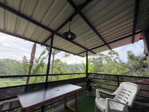a table and two chairs on a balcony with a view at Hill Nest Ella in Bandarawela