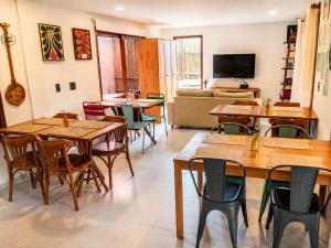 a dining room with wooden tables and chairs at Pousada Divino Milagre in Passo de Camarajibe +58 photos